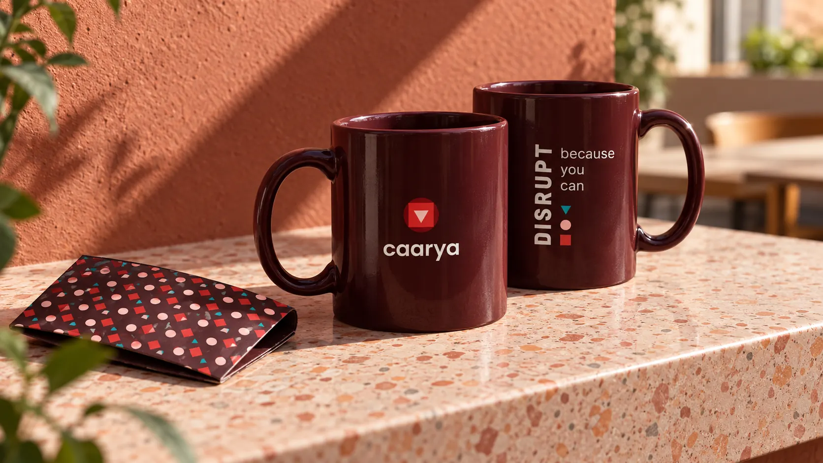 Caarya ceramic mugs and geometric packaging on a sunlit campus café ledge.